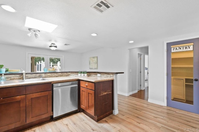 506 Broadview St, Spring Valley, CA 91977 - kitchen with stainless steel dishwasher, a skylight, light wood-style flooring, recessed lighting, and brown cabinets