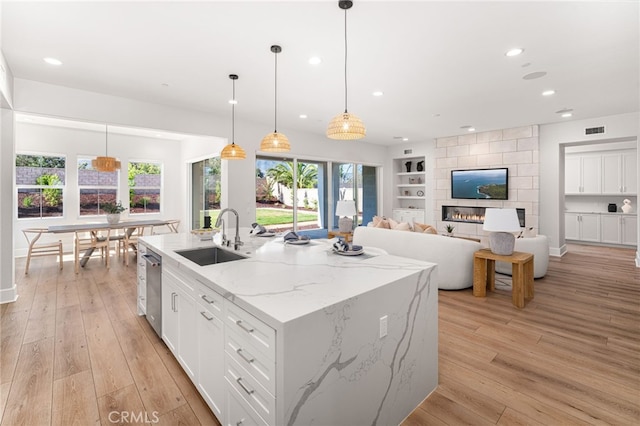 13428 Silver Sky Rd, Rancho Cucamonga, CA 91739 - kitchen featuring built in features, white cabinets, recessed lighting, a kitchen island with sink, and light wood-style floors