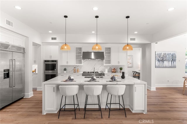 13428 Silver Sky Rd, Rancho Cucamonga, CA 91739 - kitchen featuring appliances with stainless steel finishes, under cabinet range hood, white cabinets, recessed lighting, and a center island with sink