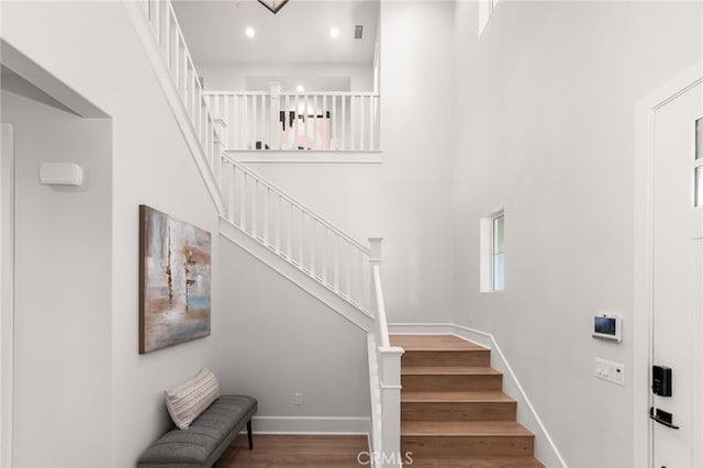 13428 Silver Sky Rd, Rancho Cucamonga, CA 91739 - staircase featuring wood finished floors, a towering ceiling, and recessed lighting
