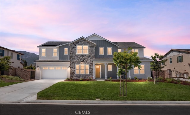 13428 Silver Sky Rd, Rancho Cucamonga, CA 91739 - craftsman-style house featuring board and batten siding, concrete driveway, a lawn, an attached garage, and stone siding