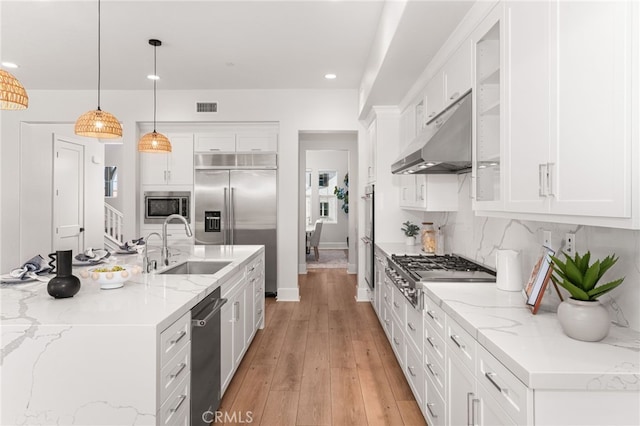 13428 Silver Sky Rd, Rancho Cucamonga, CA 91739 - kitchen featuring built in appliances, white cabinetry, hanging light fixtures, light wood finished floors, and recessed lighting