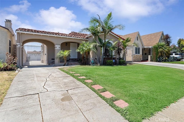 2118 W 84th St, Los Angeles, CA 90047 - mediterranean / spanish house featuring a front lawn, driveway, a tiled roof, and stucco siding