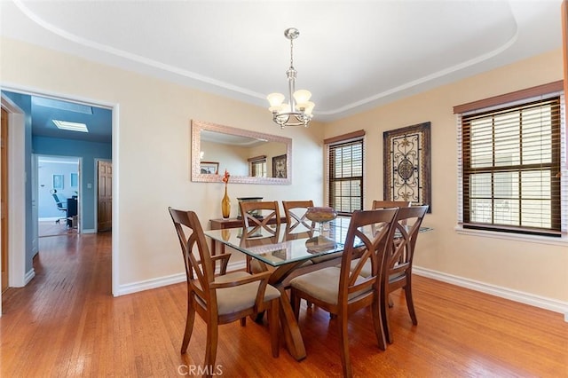 2118 W 84th St, Los Angeles, CA 90047 - dining space with a chandelier, wood finished floors, and a tray ceiling