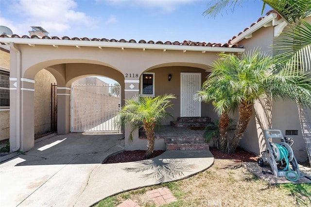 2118 W 84th St, Los Angeles, CA 90047 - view of front of house featuring stucco siding, a tile roof, driveway, and a gate
