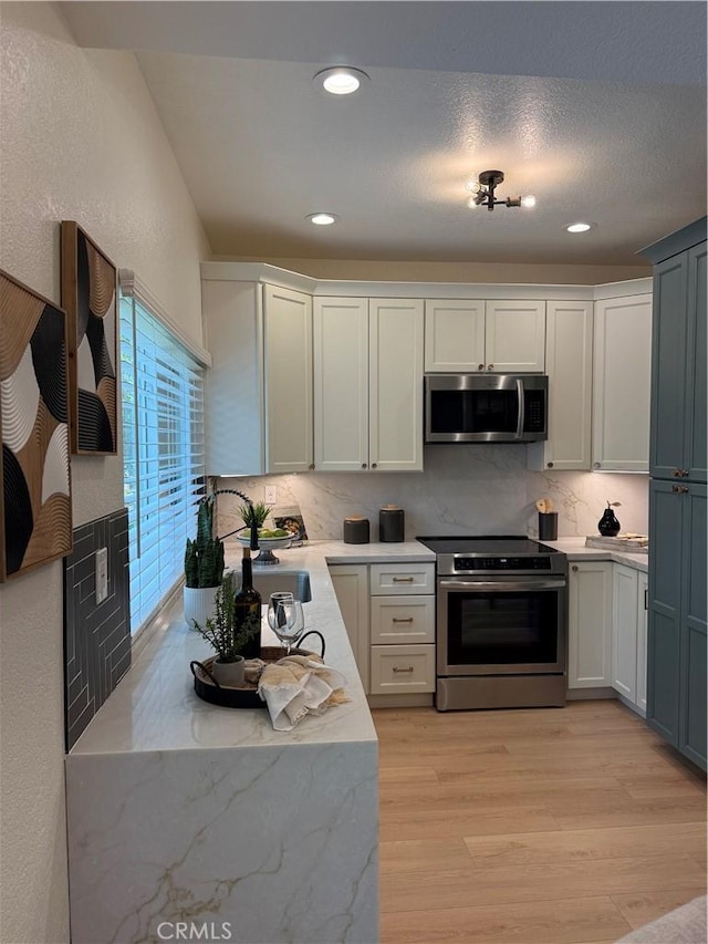 13 Silvertide Dr, Dana Point, CA 92629 - kitchen with appliances with stainless steel finishes, decorative backsplash, light wood finished floors, recessed lighting, and white cabinets