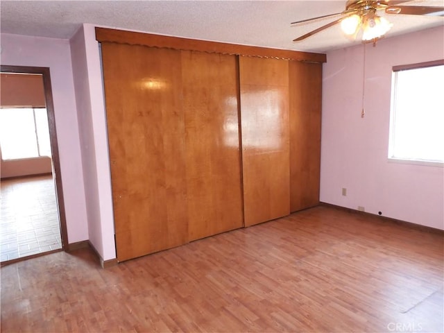 17216 Cedar Way, Clearlake Oaks, CA 95423 - unfurnished bedroom with light wood-style flooring, a closet, a ceiling fan, and a textured ceiling