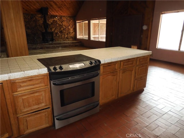 17216 Cedar Way, Clearlake Oaks, CA 95423 - kitchen featuring stainless steel range with electric cooktop, lofted ceiling, wooden ceiling, brick floors, and brown cabinets