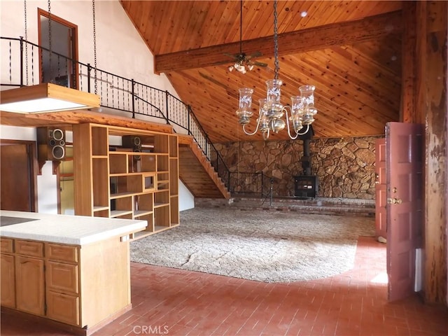 17216 Cedar Way, Clearlake Oaks, CA 95423 - unfurnished living room featuring a wood ceiling with exposed beams, stairs, high vaulted ceiling, a chandelier, and a wood stove