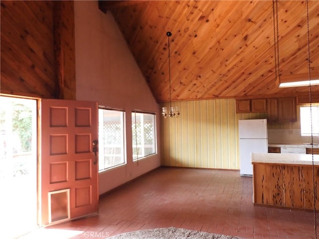 17216 Cedar Way, Clearlake Oaks, CA 95423 - unfurnished living room featuring a chandelier, high vaulted ceiling, wooden ceiling, wooden walls, and brick flooring