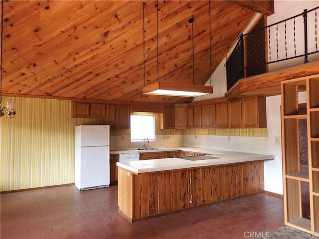 17216 Cedar Way, Clearlake Oaks, CA 95423 - kitchen with freestanding refrigerator, light countertops, a peninsula, vaulted ceiling, and brown cabinetry