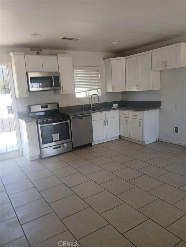 612 China Grade Loop, Bakersfield, CA 93308 - kitchen with appliances with stainless steel finishes, healthy amount of natural light, white cabinets, dark countertops, and recessed lighting