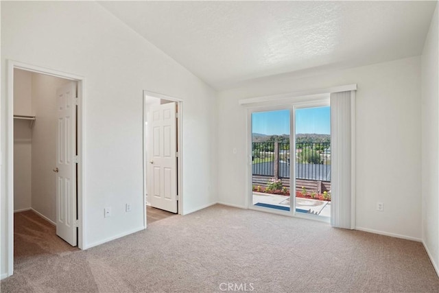 20128 Shadow Island Dr, Canyon Country, CA 91351 - unfurnished bedroom featuring carpet flooring, access to outside, a walk in closet, vaulted ceiling, and a textured ceiling
