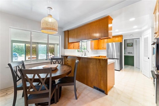 2117 N Westwood Ave, Santa Ana, CA 92706 - kitchen featuring freestanding refrigerator, a peninsula, light flooring, and plenty of natural light