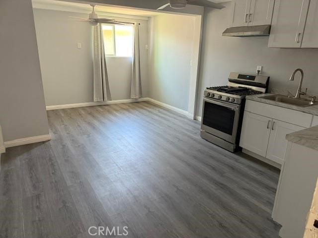 830 W Heber St, Glendora, CA 91741 - kitchen with stainless steel gas range, under cabinet range hood, a ceiling fan, white cabinetry, and wood finished floors