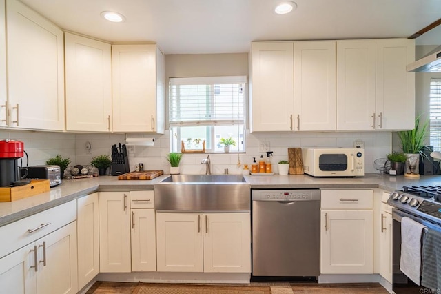 3721 Chamoune Ave, San Diego, CA 92105 - kitchen featuring appliances with stainless steel finishes, light countertops, white cabinets, plenty of natural light, and recessed lighting