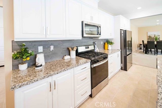30106 Stargazer Way, Menifee, CA 92584 - kitchen featuring appliances with stainless steel finishes, white cabinets, and backsplash