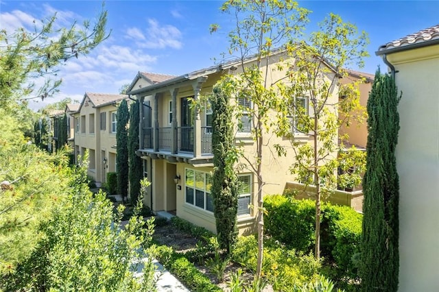 111 Thornhurst, Irvine, CA 92620 - view of side of home featuring stucco siding, a balcony, and a tile roof