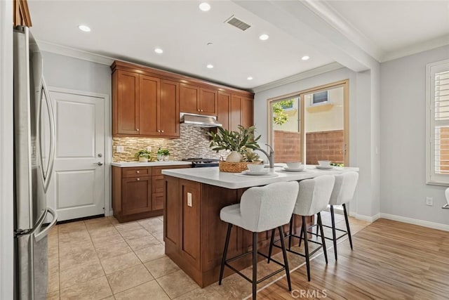 111 Thornhurst, Irvine, CA 92620 - kitchen with freestanding refrigerator, ornamental molding, light countertops, backsplash, and a breakfast bar area