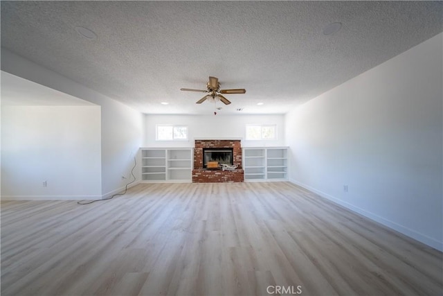 16520 Adelia St, Hesperia, CA 92345 - unfurnished living room with a ceiling fan, light wood-style flooring, a textured ceiling, and a fireplace