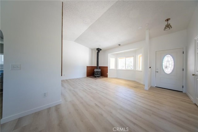 16520 Adelia St, Hesperia, CA 92345 - entryway featuring a wood stove, a textured ceiling, light wood-style floors, and lofted ceiling