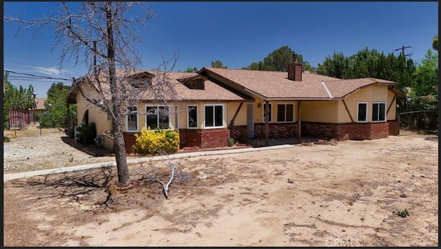 16520 Adelia St, Hesperia, CA 92345 - view of front facade with stucco siding, a chimney, and brick siding