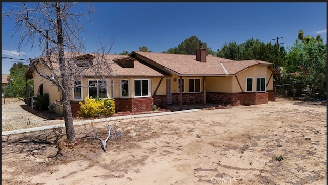 16520 Adelia St, Hesperia, CA 92345 - view of front of house with stucco siding, a chimney, and brick siding