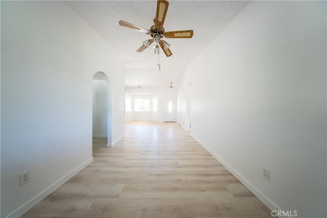 16520 Adelia St, Hesperia, CA 92345 - corridor featuring arched walkways, light wood-style flooring, and a textured ceiling