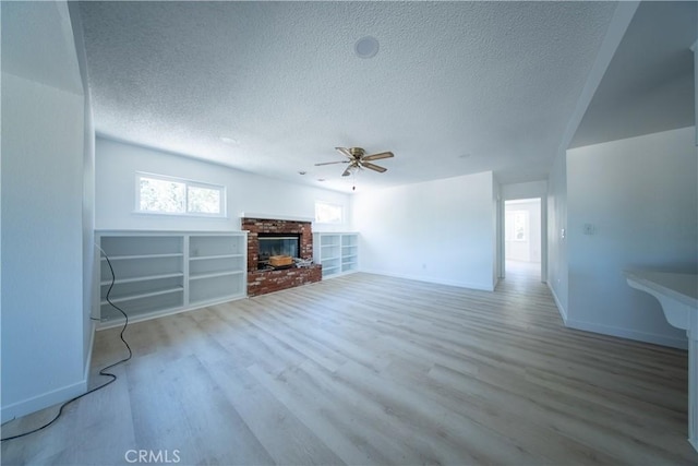 16520 Adelia St, Hesperia, CA 92345 - unfurnished living room featuring ceiling fan, a textured ceiling, wood finished floors, and a fireplace