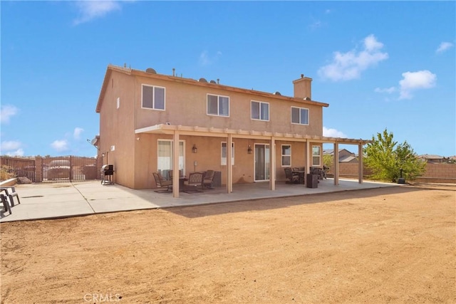 13695 Mesa Linda Ave, Victorville, CA 92392 - back of property with stucco siding, a fenced backyard, a chimney, a patio, and a gate