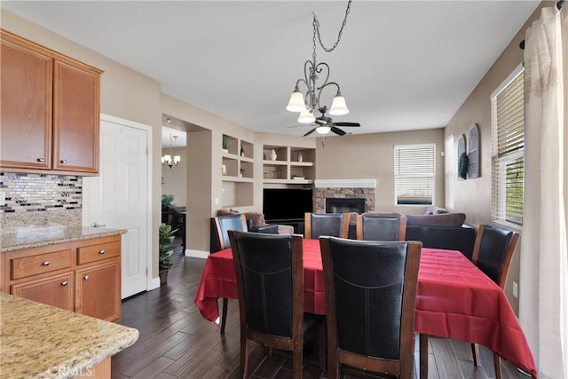 13695 Mesa Linda Ave, Victorville, CA 92392 - dining area featuring a chandelier, a fireplace, dark wood-style flooring, built in features, and a ceiling fan