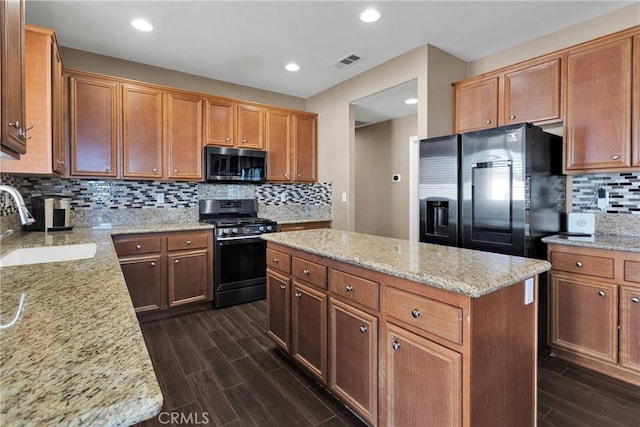 13695 Mesa Linda Ave, Victorville, CA 92392 - kitchen featuring appliances with stainless steel finishes, a kitchen island, dark wood-style floors, decorative backsplash, and light stone countertops