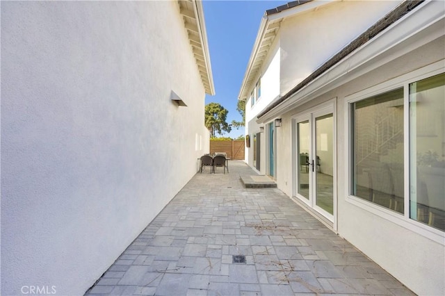 5042 Olympic Dr, Los Alamitos, CA 90720 - view of side of property with stucco siding, a patio, and french doors