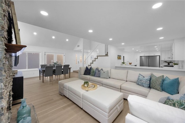 5042 Olympic Dr, Los Alamitos, CA 90720 - living room featuring light wood-style floors, stairway, a stone fireplace, and recessed lighting