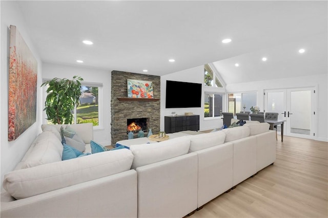 5042 Olympic Dr, Los Alamitos, CA 90720 - living area with healthy amount of natural light, a stone fireplace, light wood finished floors, lofted ceiling, and recessed lighting