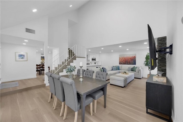 5042 Olympic Dr, Los Alamitos, CA 90720 - dining space featuring stairway, high vaulted ceiling, light wood finished floors, and recessed lighting