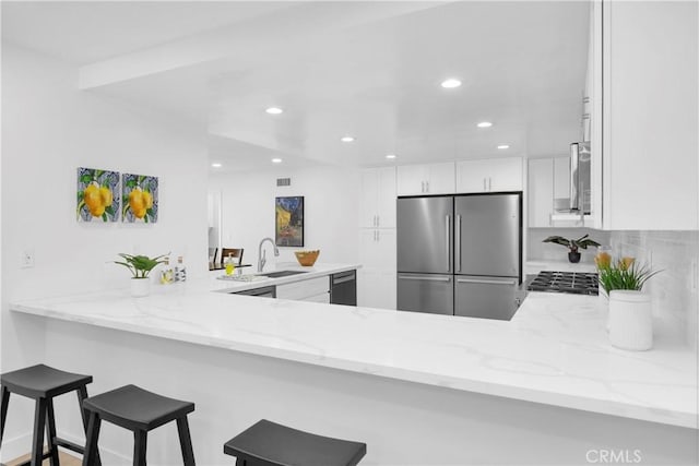 5042 Olympic Dr, Los Alamitos, CA 90720 - kitchen with stainless steel refrigerator, a peninsula, black dishwasher, recessed lighting, and white cabinets