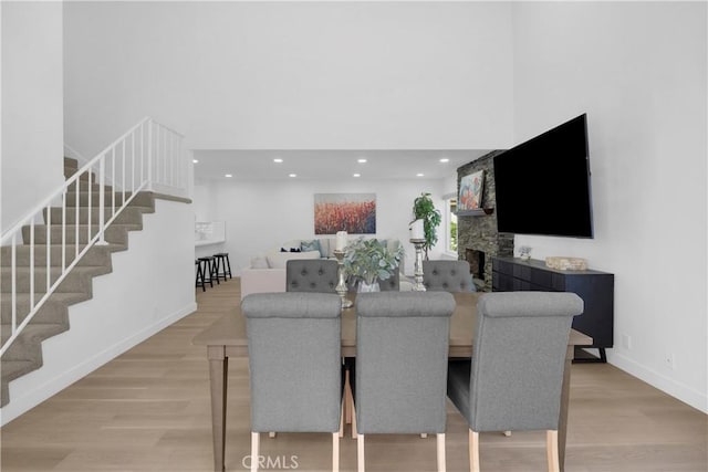 5042 Olympic Dr, Los Alamitos, CA 90720 - dining room with stairway, light wood-type flooring, recessed lighting, and a fireplace