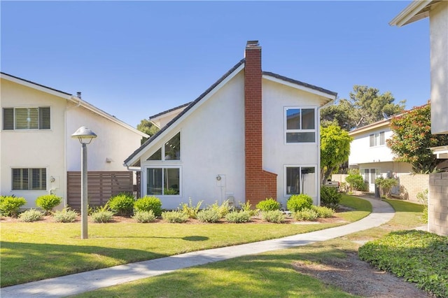 5042 Olympic Dr, Los Alamitos, CA 90720 - view of side of home featuring stucco siding, a yard, and a chimney