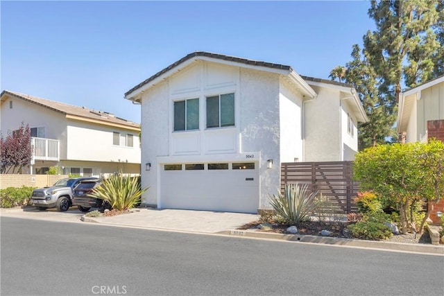 5042 Olympic Dr, Los Alamitos, CA 90720 - view of front facade with stucco siding, a garage, and driveway
