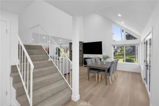 5042 Olympic Dr, Los Alamitos, CA 90720 - stairway featuring wood finished floors, high vaulted ceiling, and recessed lighting