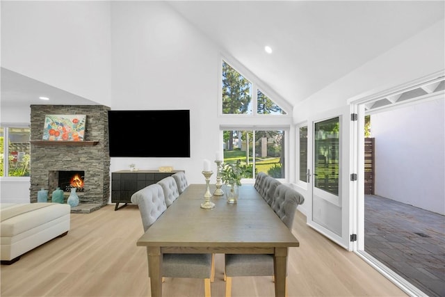 5042 Olympic Dr, Los Alamitos, CA 90720 - dining area with high vaulted ceiling, healthy amount of natural light, light wood-style flooring, a stone fireplace, and recessed lighting