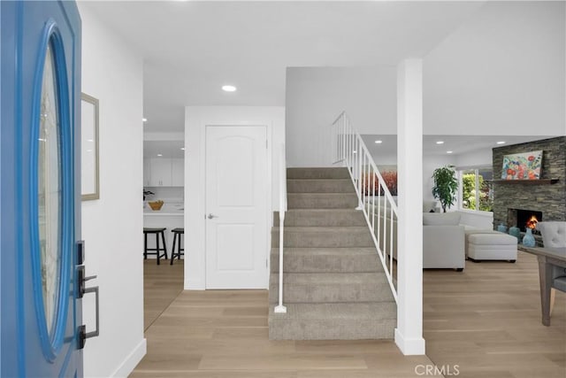 5042 Olympic Dr, Los Alamitos, CA 90720 - foyer entrance featuring stairway, wood finished floors, recessed lighting, and a fireplace
