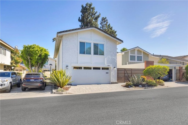5042 Olympic Dr, Los Alamitos, CA 90720 - view of front facade with an attached garage, driveway, and stucco siding