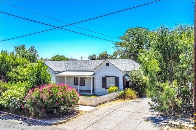 559 Edgar Ave Unit A2-282, Beaumont, CA 92223 - ranch-style house featuring roof with shingles, a fenced front yard, driveway, and covered porch