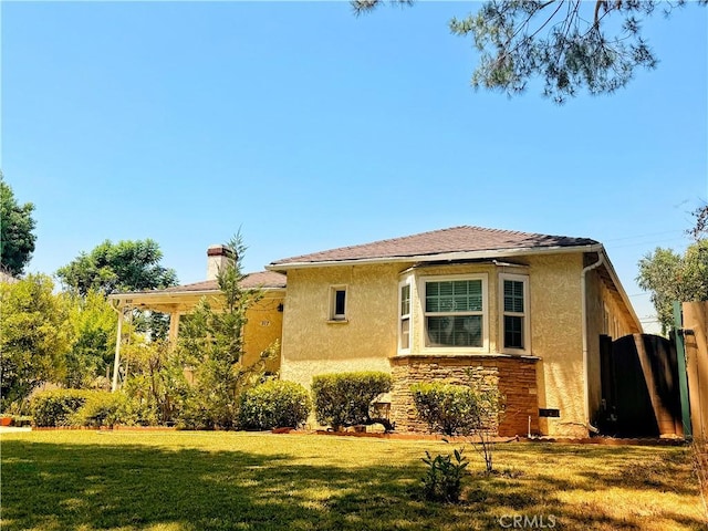 917 N Olive Ave, Alhambra, CA 91801 - view of side of home with stucco siding, a chimney, and stone siding