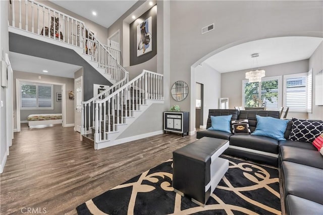 7020 Julie Ln, San Gabriel, CA 91775 - living area featuring arched walkways, a chandelier, stairs, wood finished floors, and a high ceiling