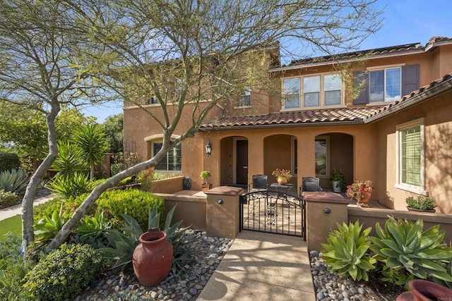 3024 Natureview Ct, Chula Vista, CA 91914 - mediterranean / spanish home featuring a fenced front yard, stucco siding, a gate, a tiled roof, and covered porch