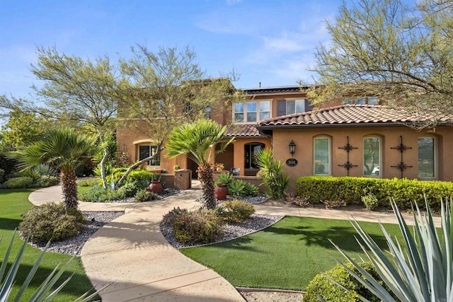 3024 Natureview Ct, Chula Vista, CA 91914 - mediterranean / spanish house featuring a tile roof, a front lawn, stucco siding, and roof mounted solar panels