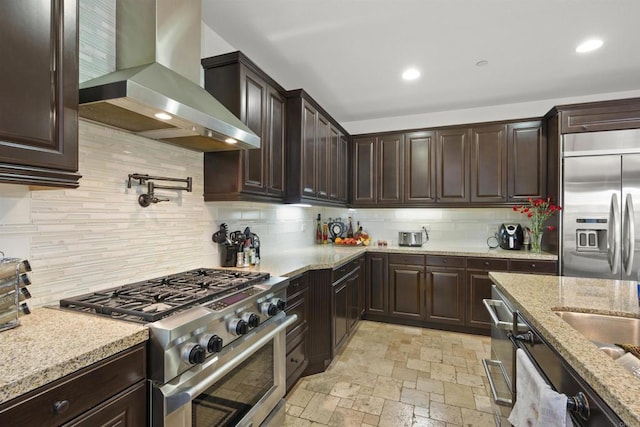 3024 Natureview Ct, Chula Vista, CA 91914 - kitchen with wall chimney exhaust hood, stainless steel appliances, backsplash, dark brown cabinets, and recessed lighting